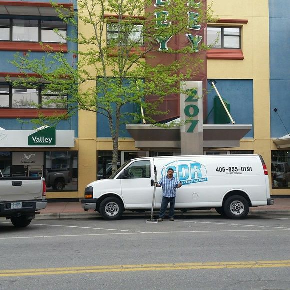 A cdr van is parked in front of a building
