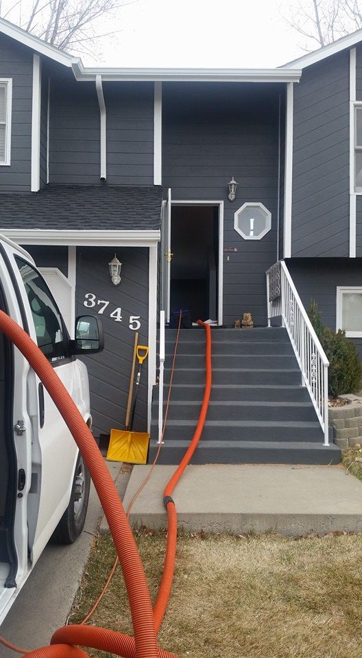 A white truck is parked in front of a house with stairs.