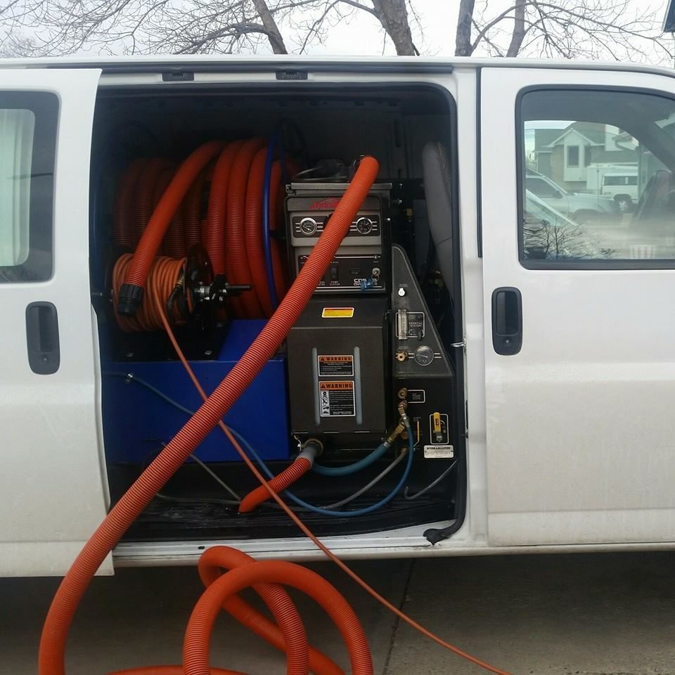 A white van with a bunch of hoses attached to it