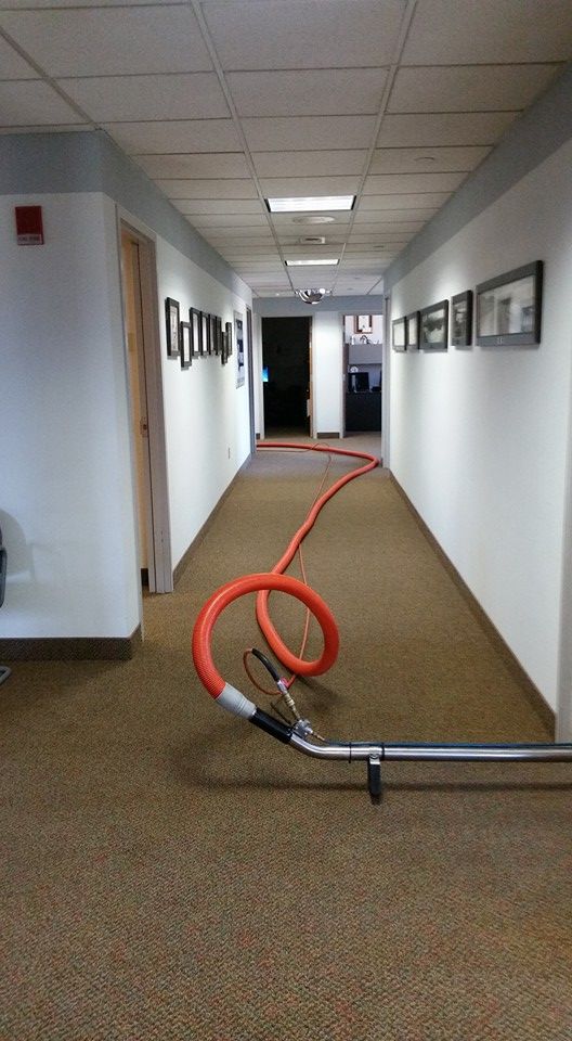 A long hallway with a vacuum hose in the middle of it.
