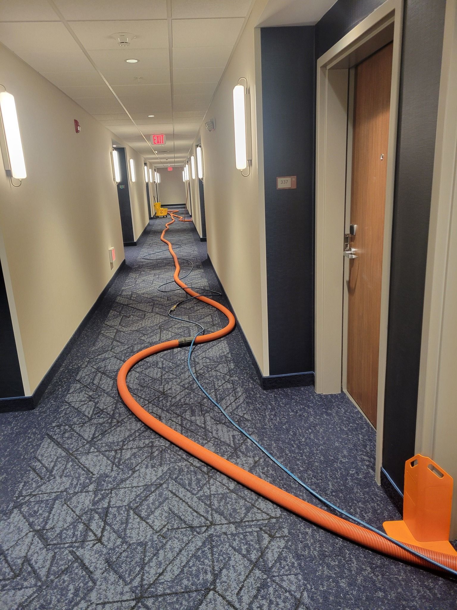 A long hallway with a vacuum hose going down it.