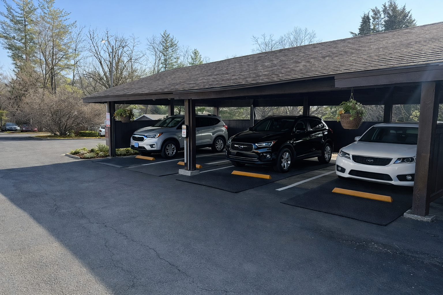 Cars parked under a brown-roofed carport with designated parking spots marked by yellow blocks.