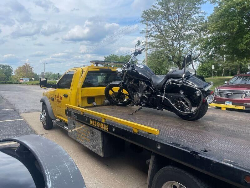 A motorcycle is sitting on top of a tow truck.