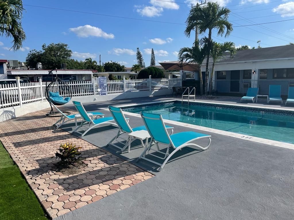 Poolside scene with blue lounge chairs and a clear pool under a sunny sky.