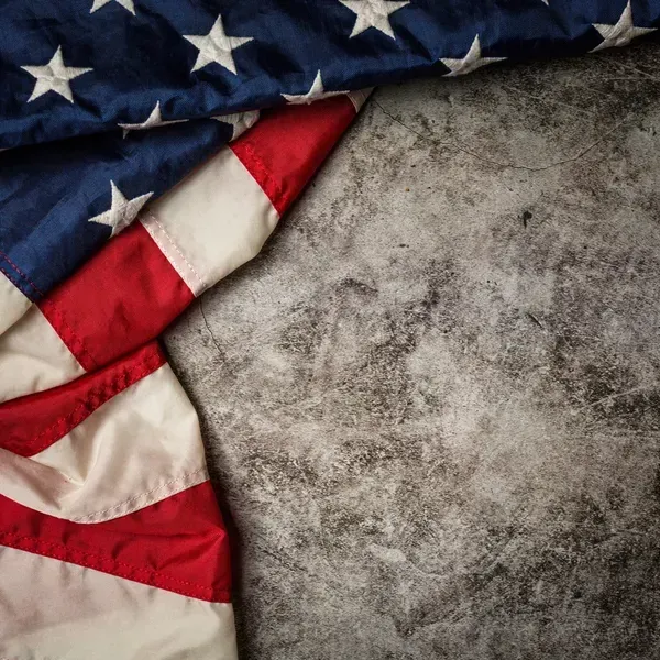 A person is holding a pineapple in a bag in a grocery store.