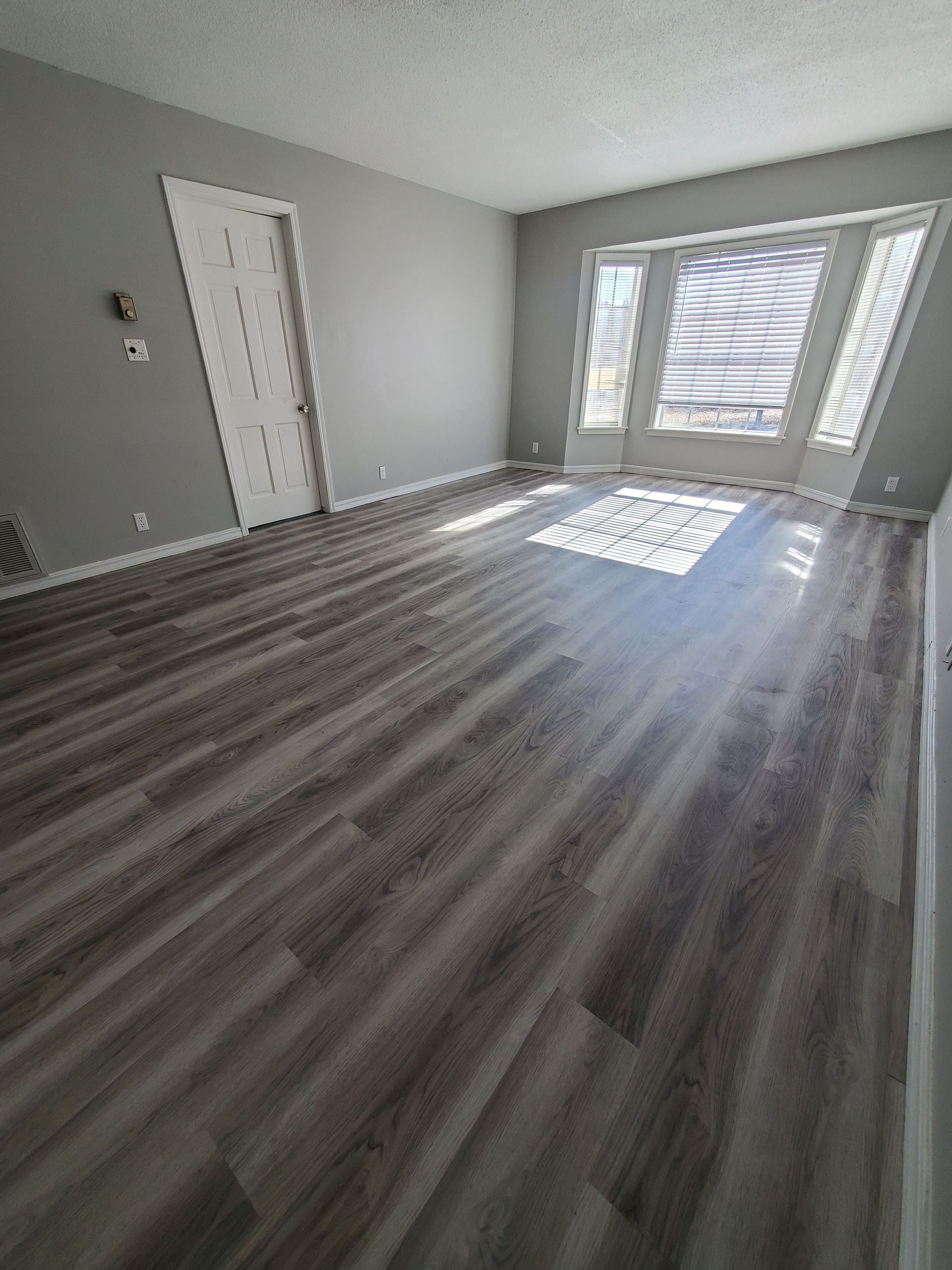 A living room with hardwood floors and a sliding glass door.