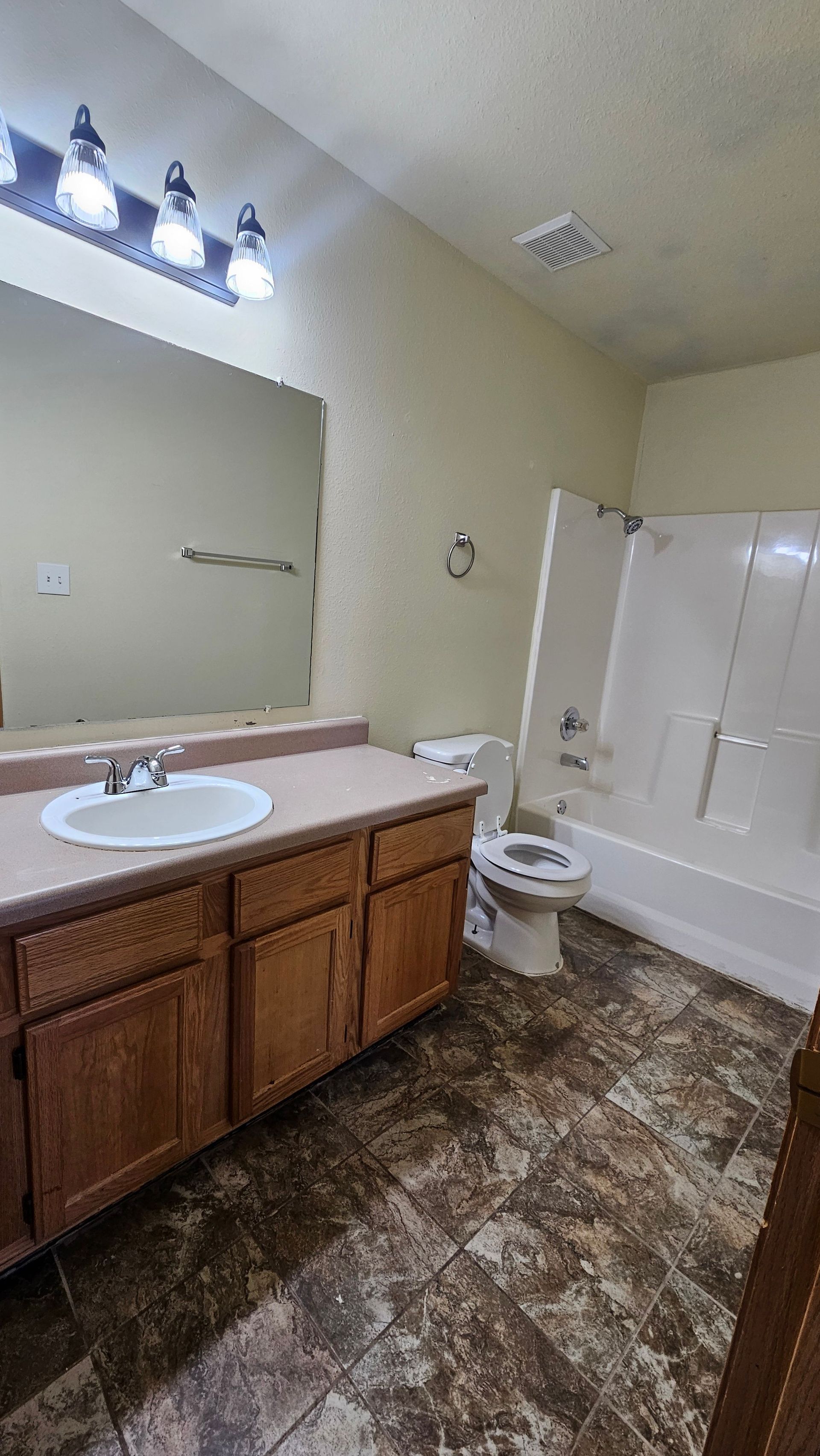 A bathroom with a sink , toilet , bathtub and mirror.