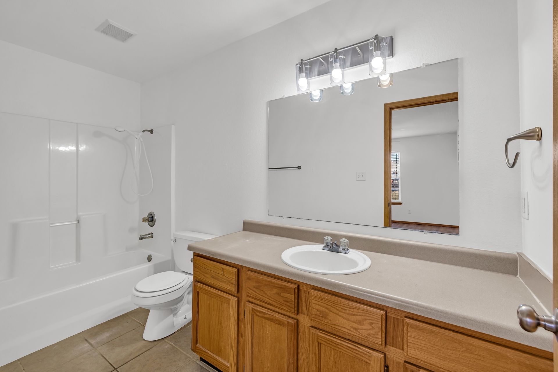 A bathroom with a sink , toilet , bathtub and mirror.