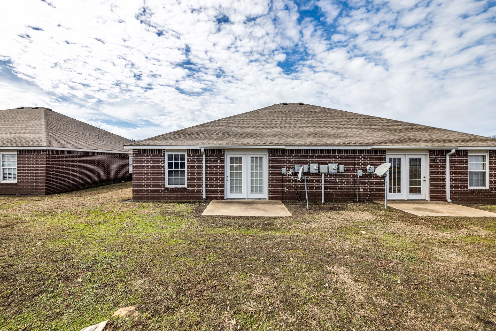 A couple of houses are sitting next to each other in a field.