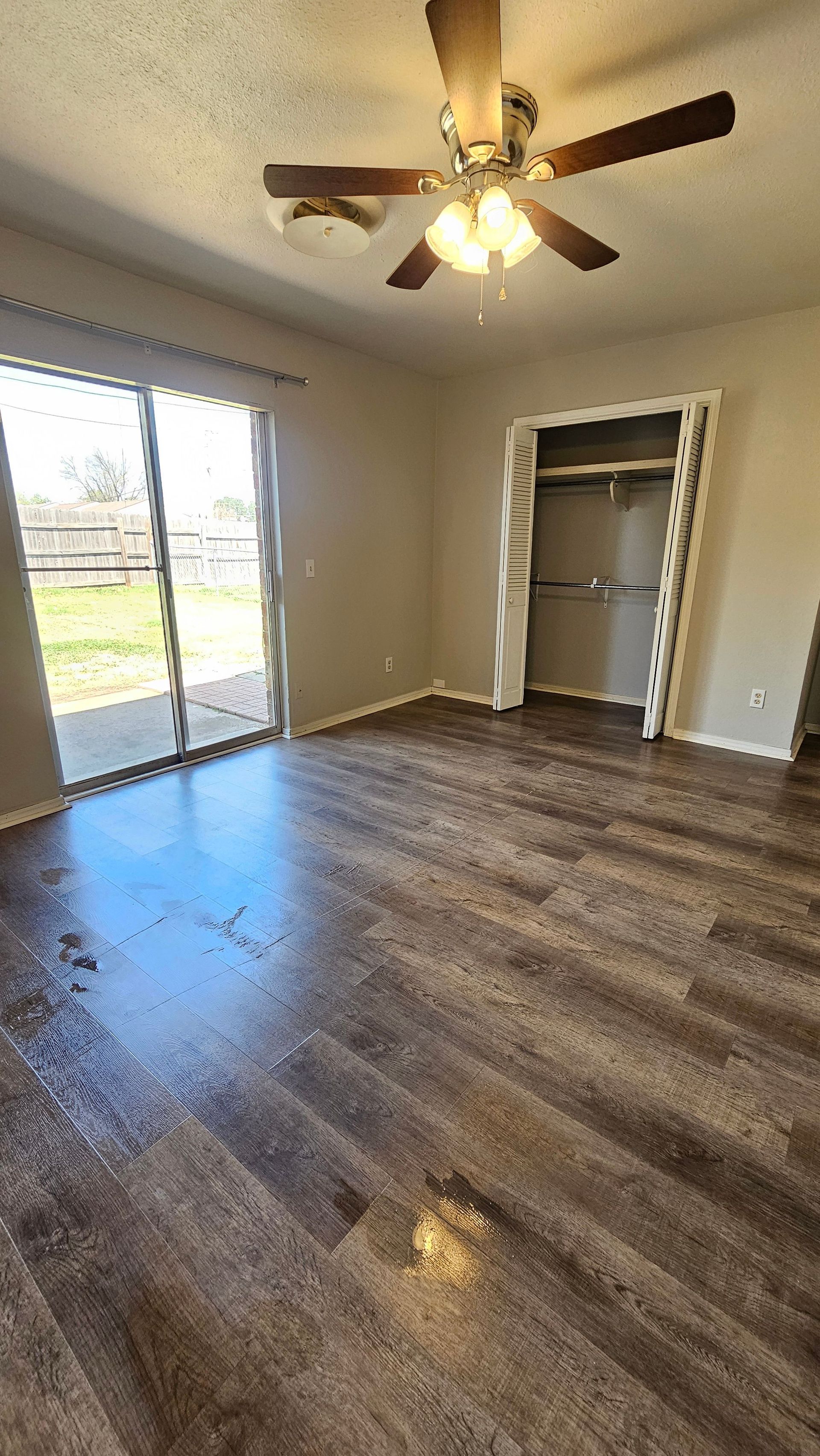 A living room with hardwood floors and a ceiling fan.