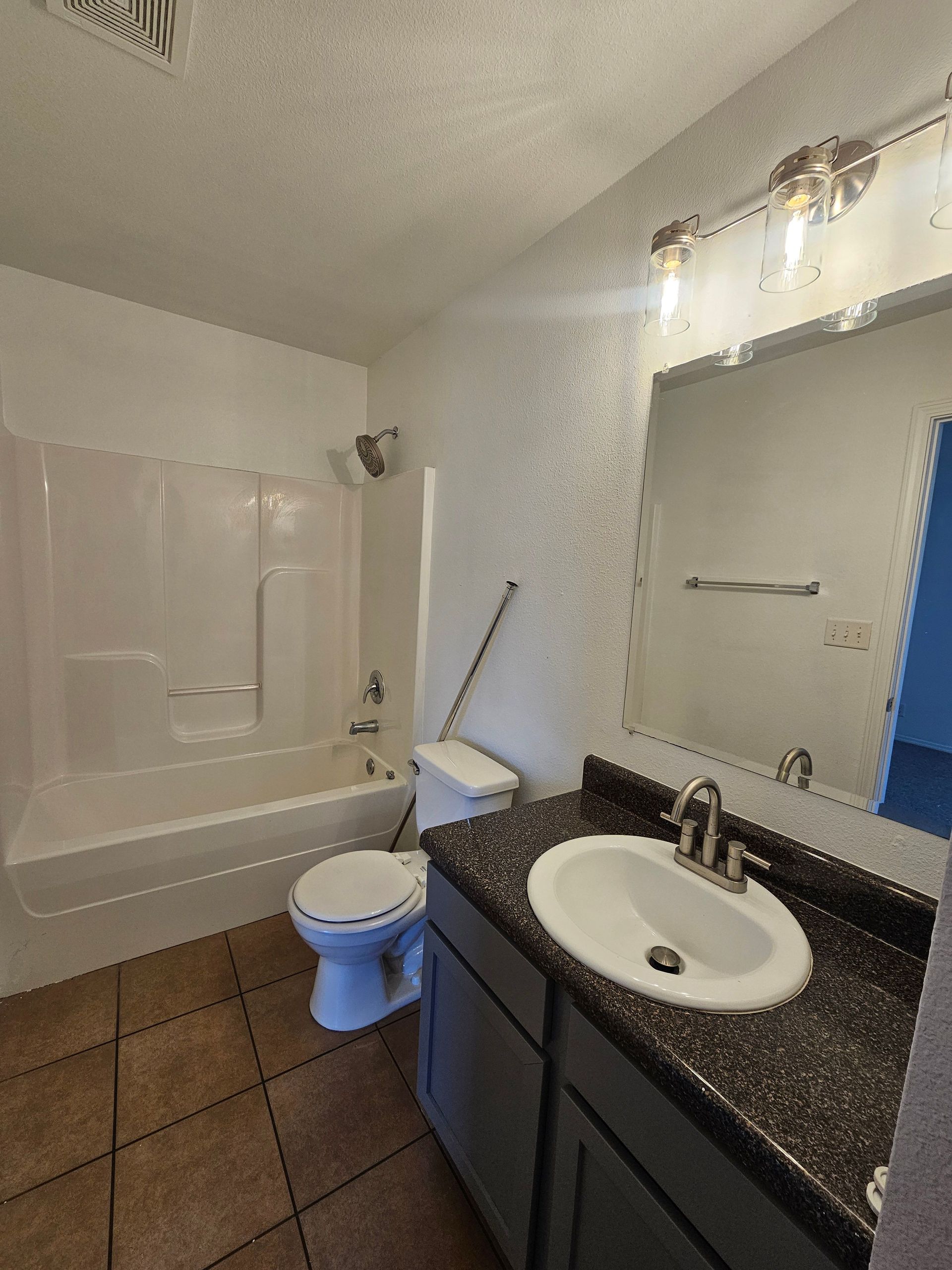 A bathroom with a sink , toilet , bathtub and mirror