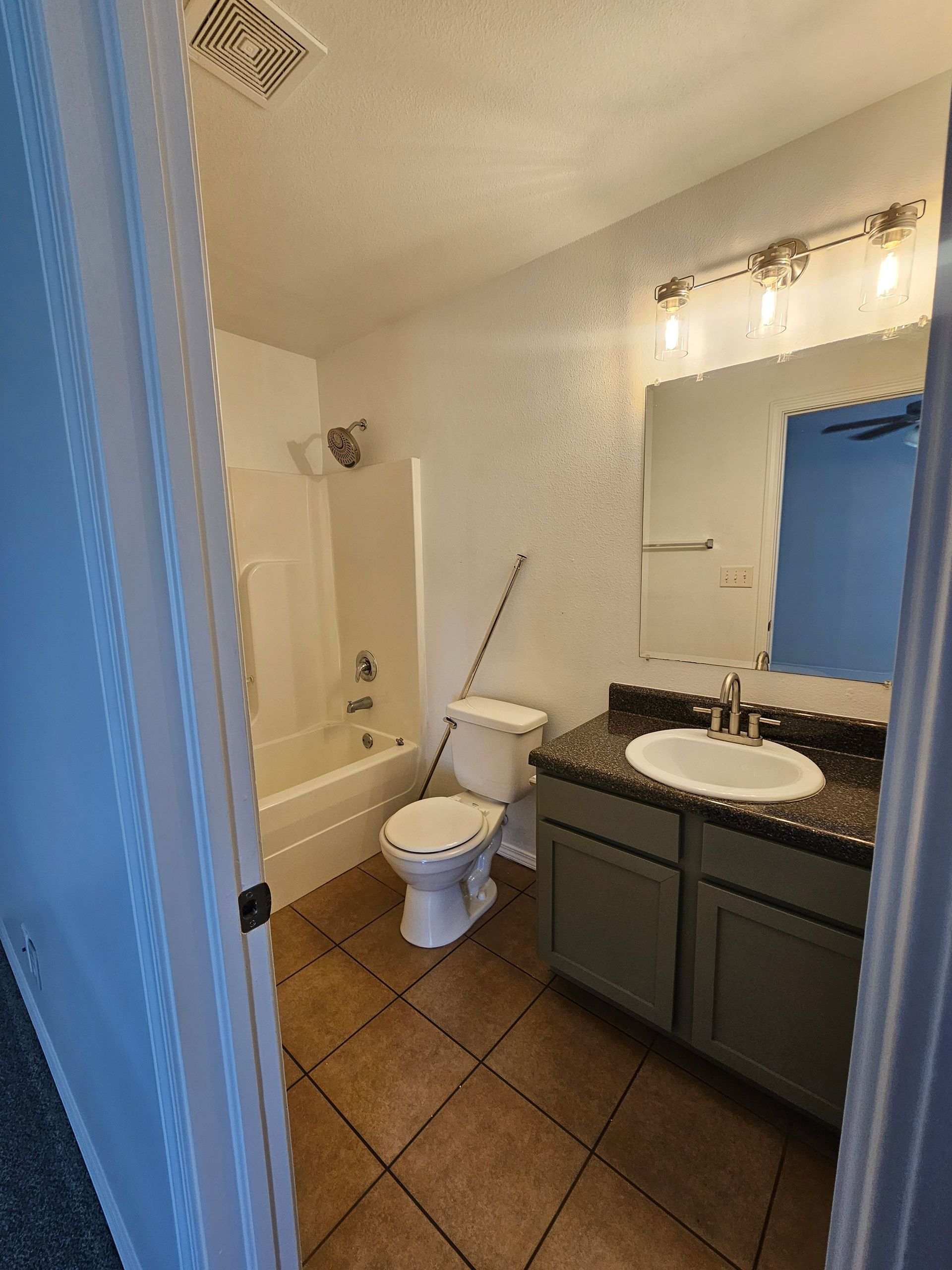 A bathroom with a toilet , sink , and bathtub.