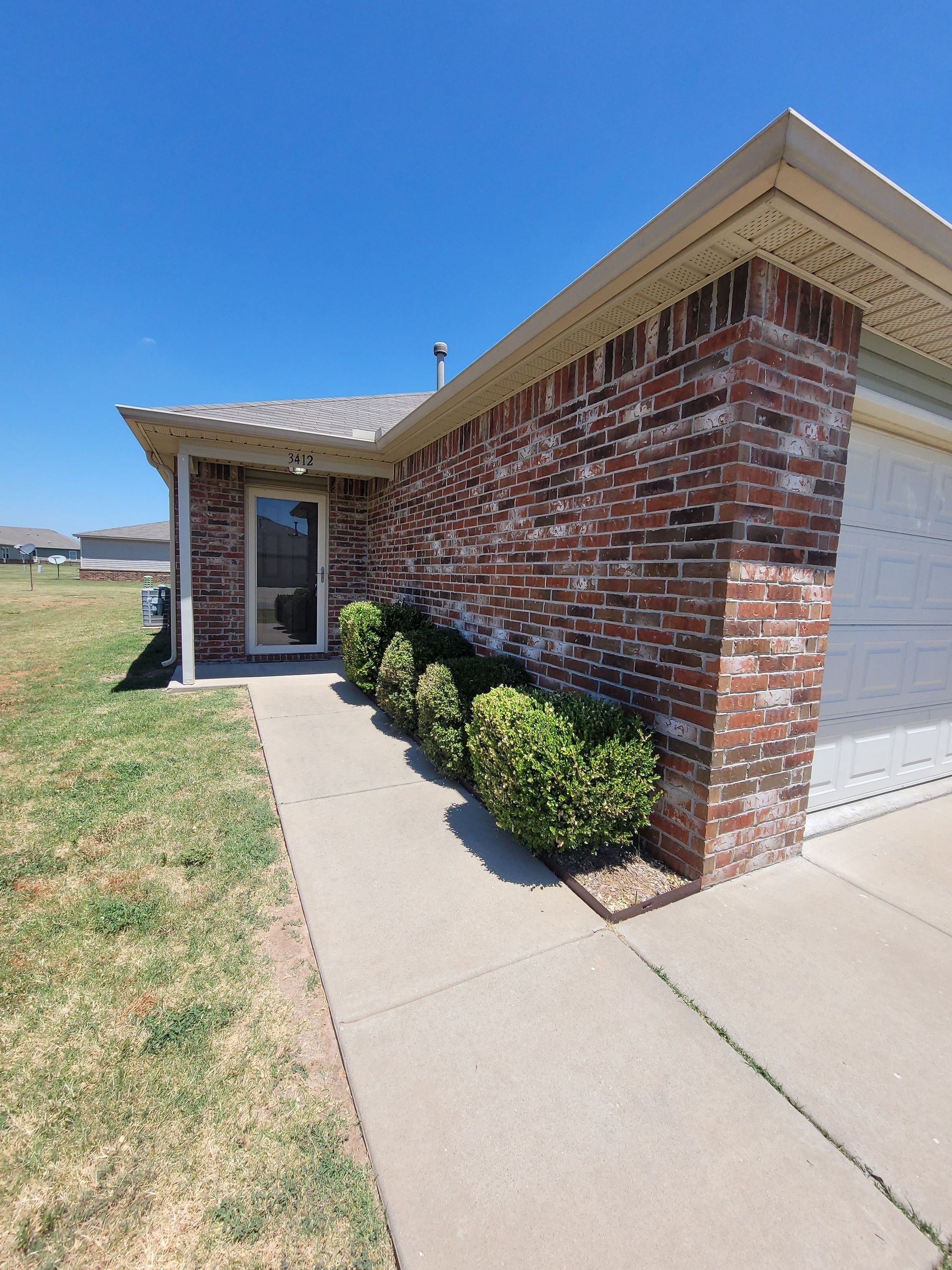 A house with a brick wall and a white garage door