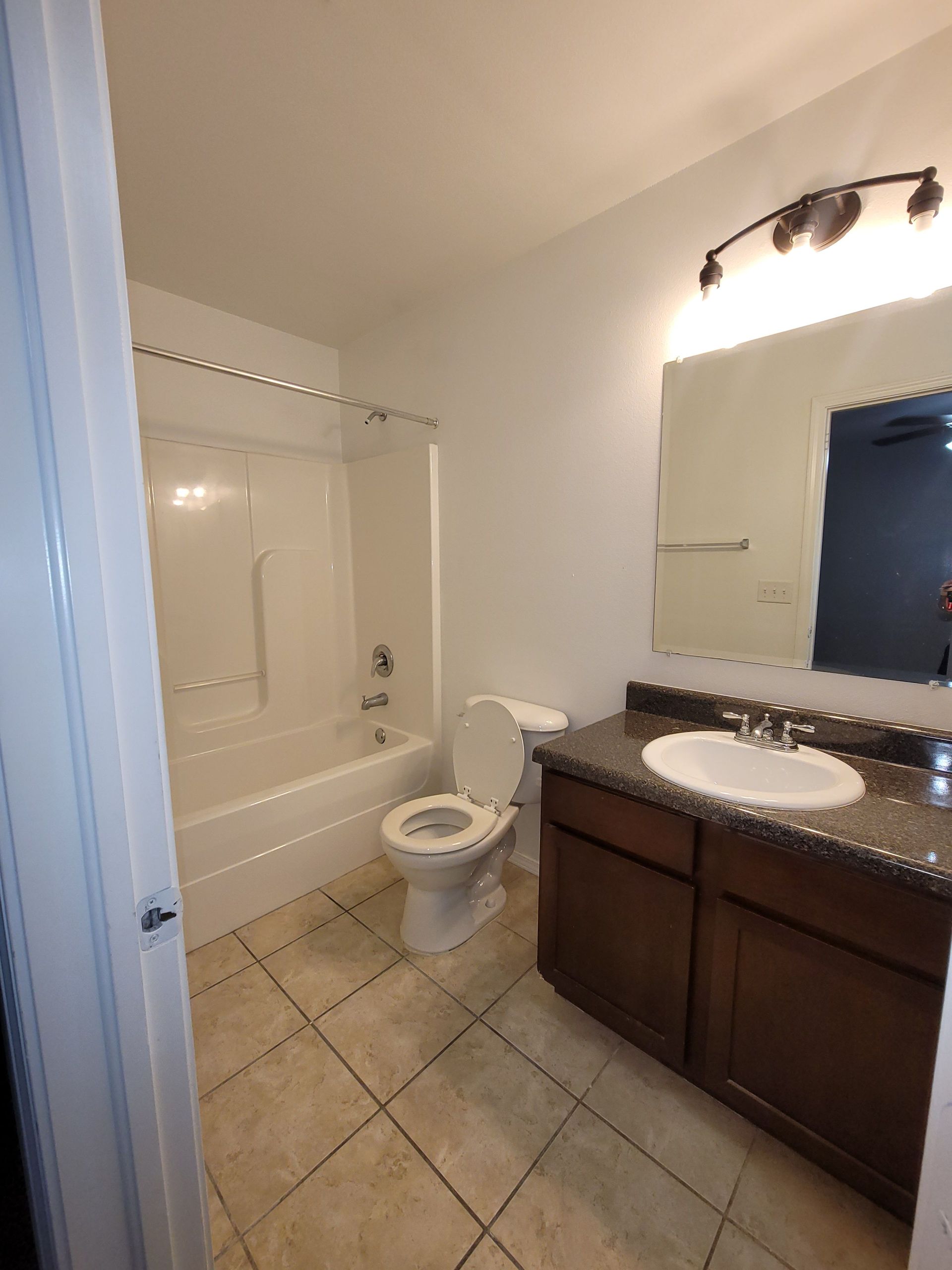 A bathroom with a toilet , sink and bathtub.