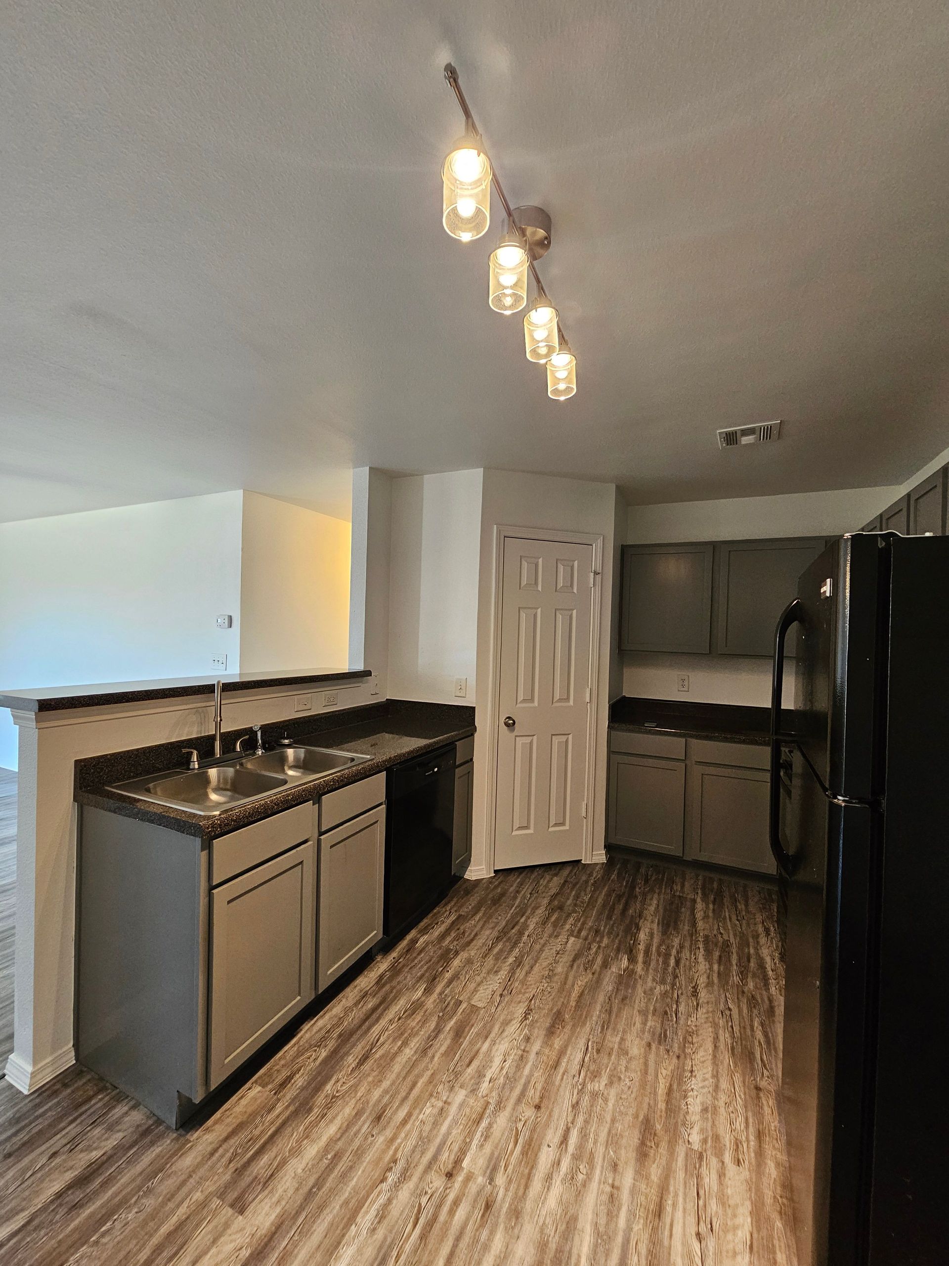 A kitchen with stainless steel appliances and wooden floors