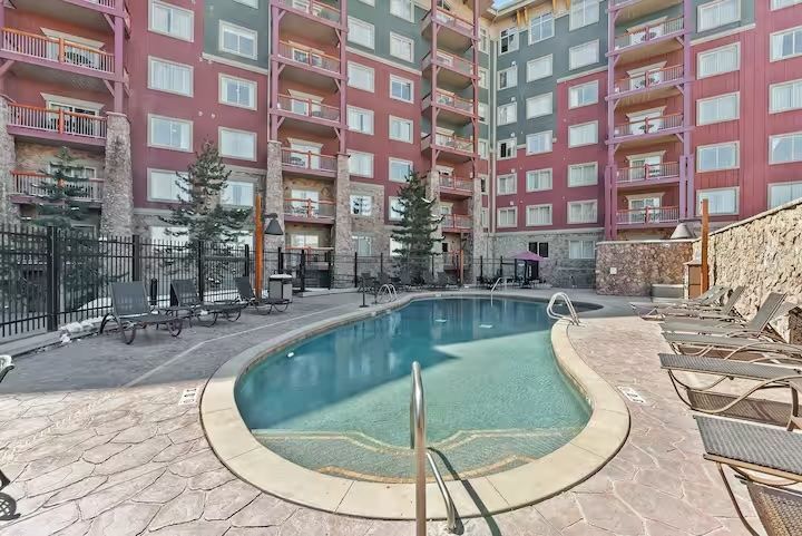 There is a large swimming pool in the middle of a building.