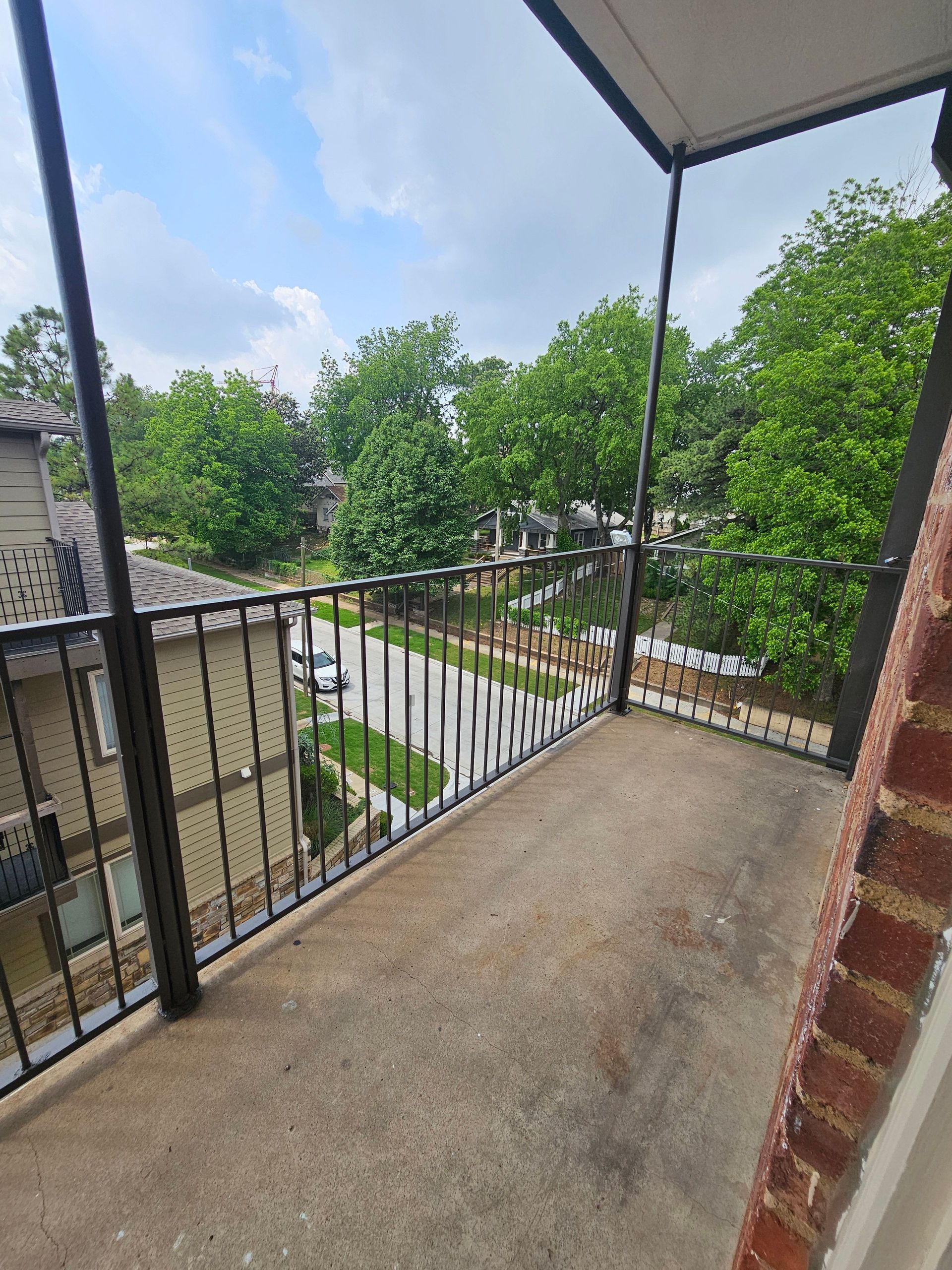 A balcony with a railing and a view of a residential area.