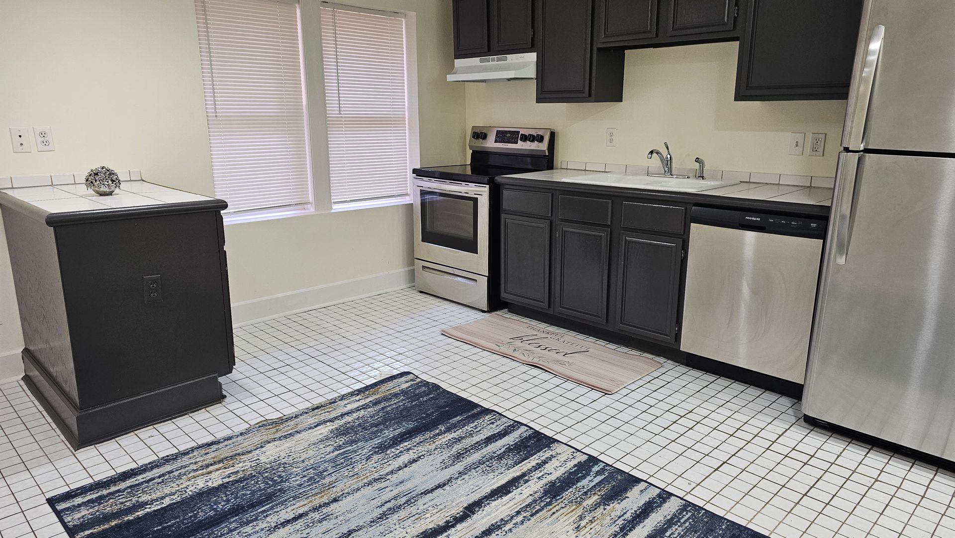 A kitchen with black cabinets and stainless steel appliances.