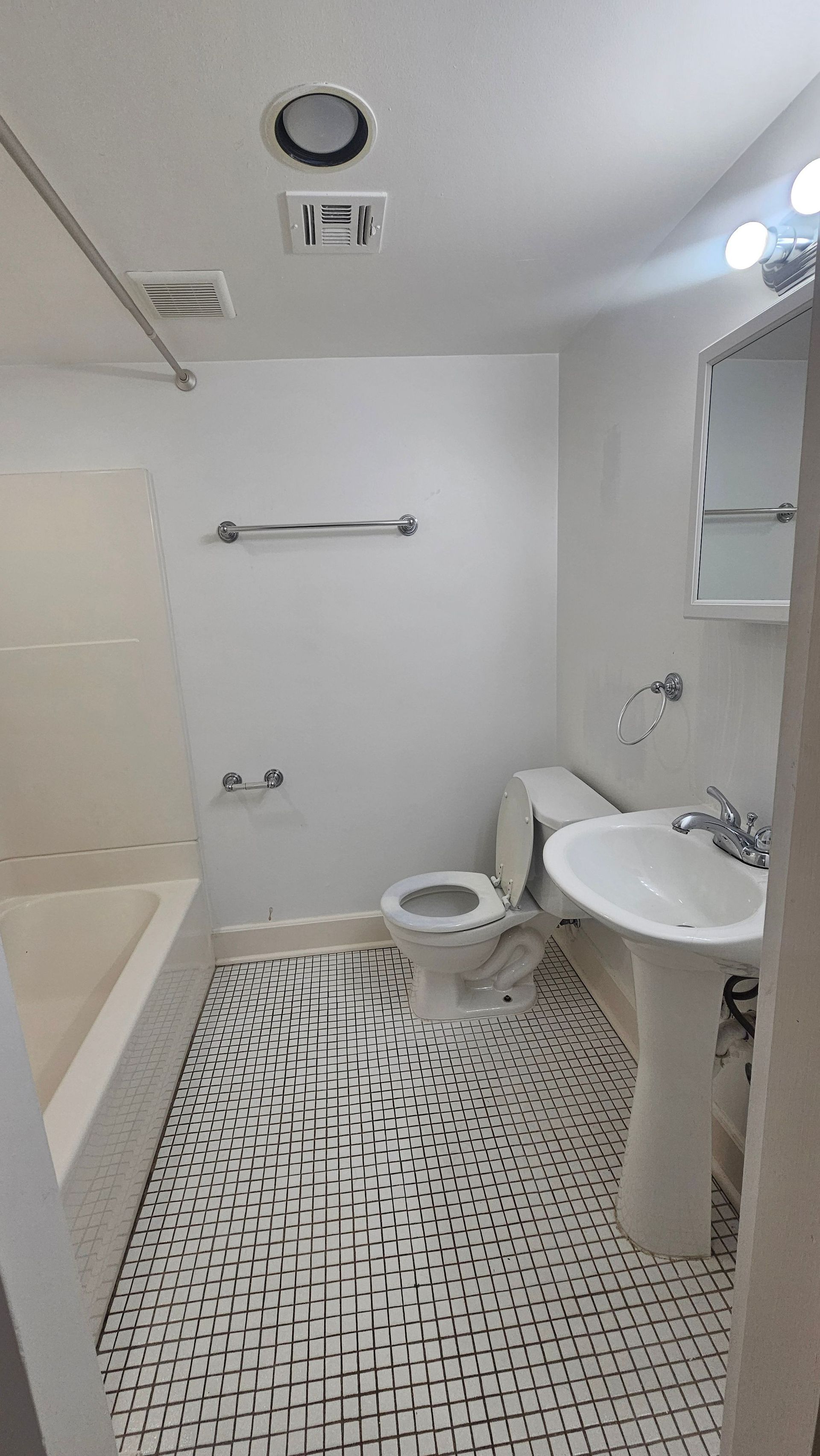 A bathroom with a toilet , sink , and bathtub.