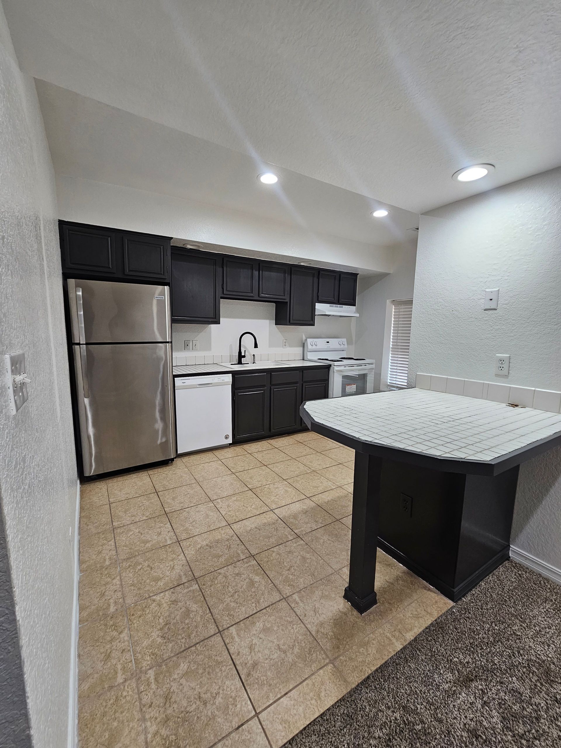 A kitchen with stainless steel appliances and black cabinets
