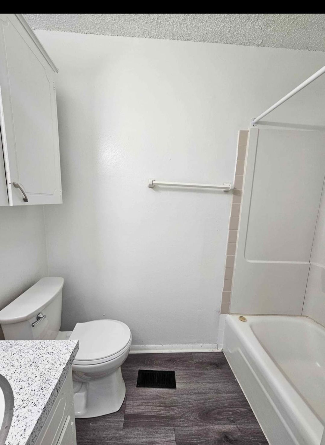 A bathroom with a toilet , sink and bathtub.