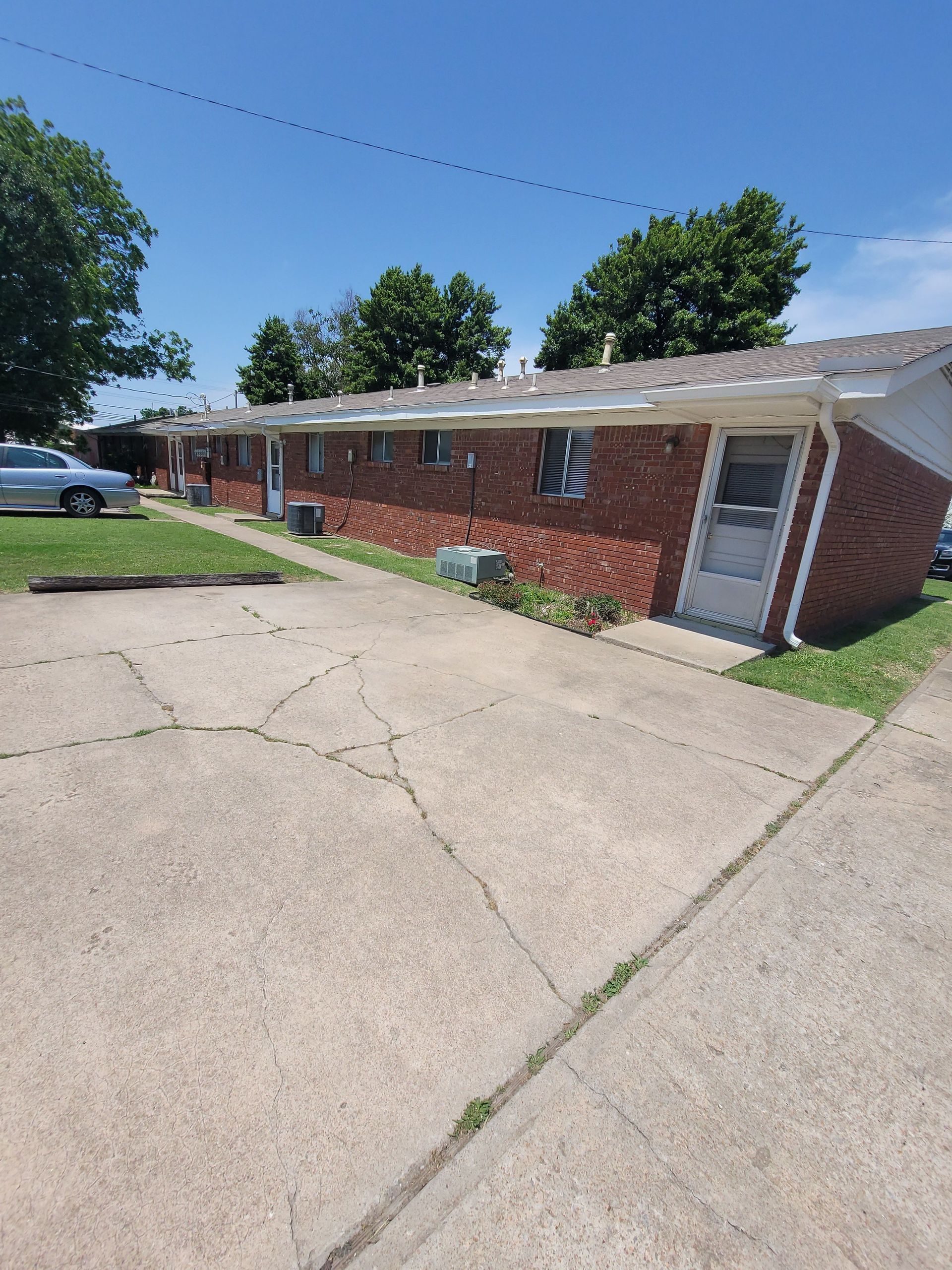 A car is parked in front of a brick building