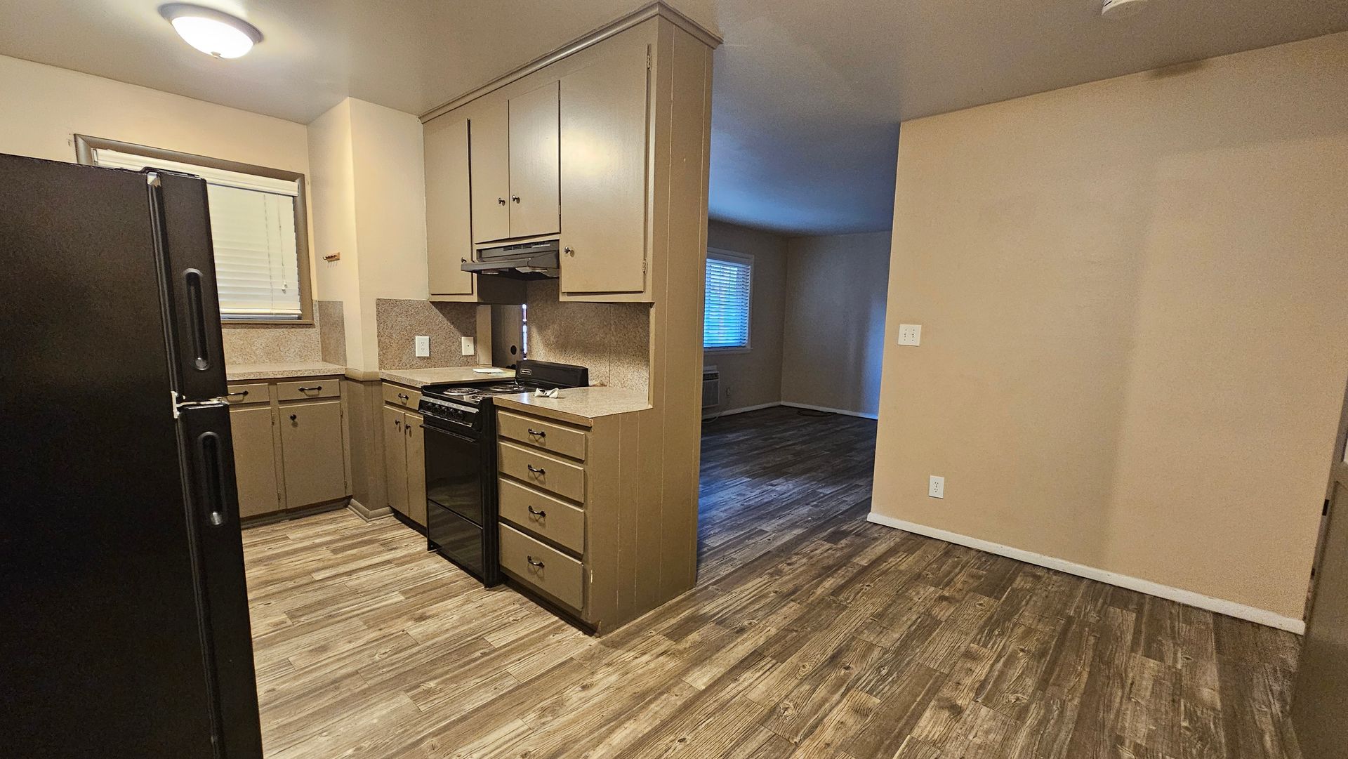 A kitchen with a black refrigerator , stove , and sink.