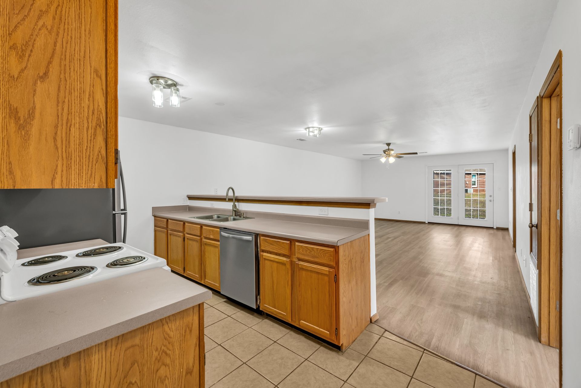 A kitchen with wooden cabinets , a stove and a dishwasher.