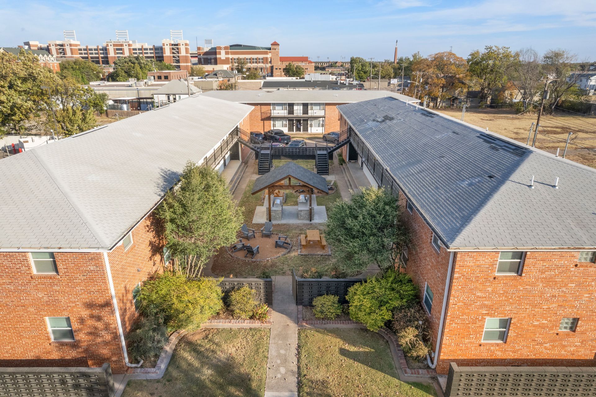 An aerial view of a brick apartment building with a courtyard in the middle.