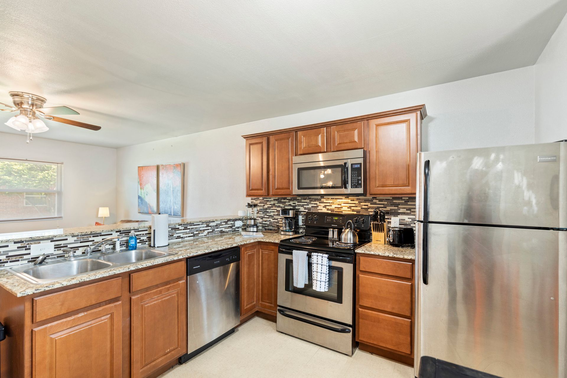A kitchen with stainless steel appliances and wooden cabinets.