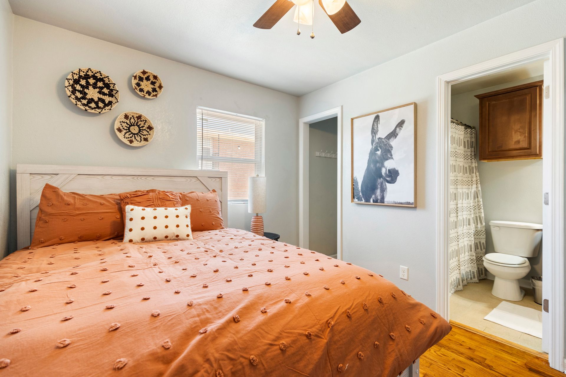 A bedroom with a bed , toilet , and ceiling fan.