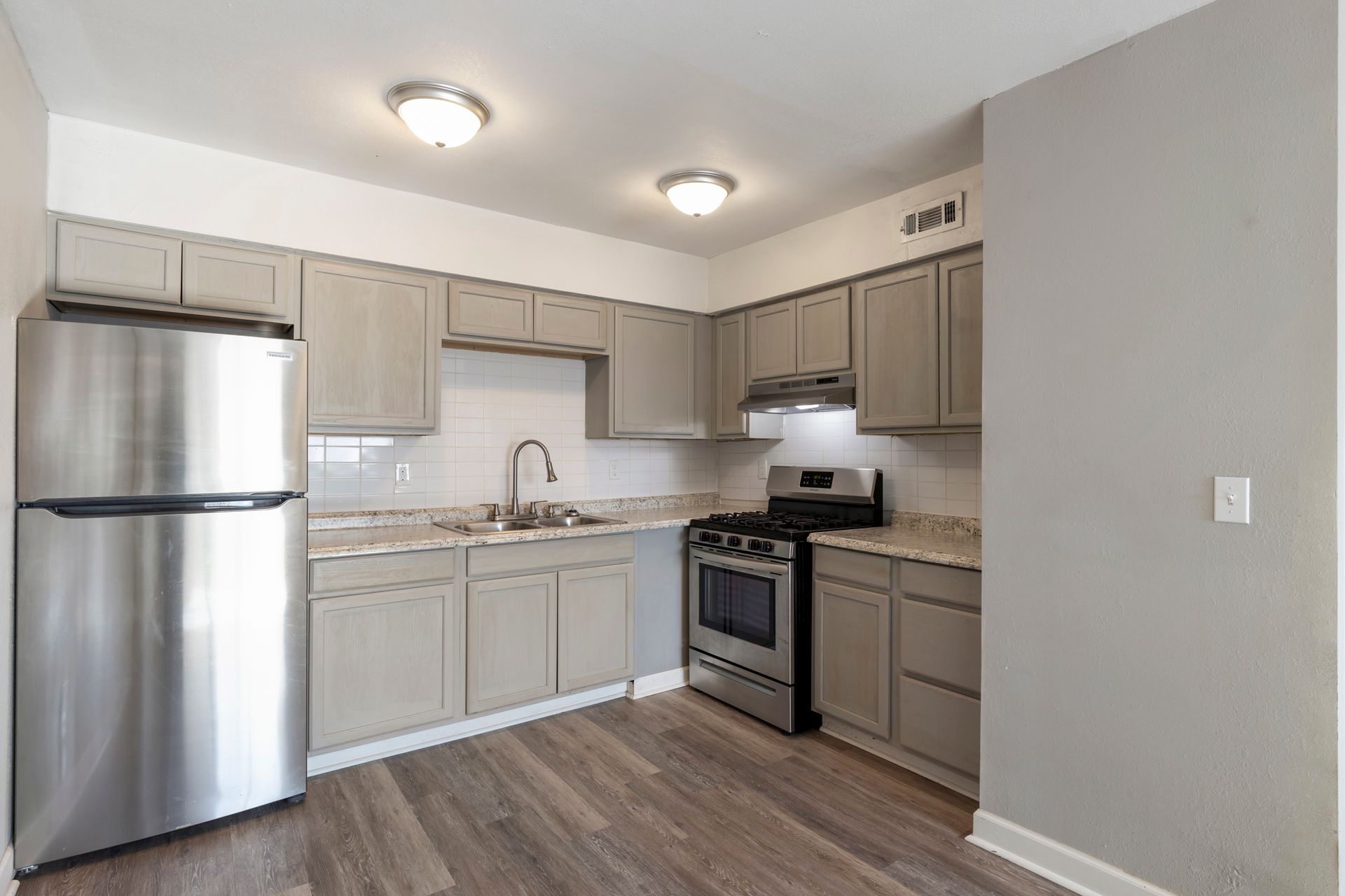 A kitchen with stainless steel appliances and gray cabinets