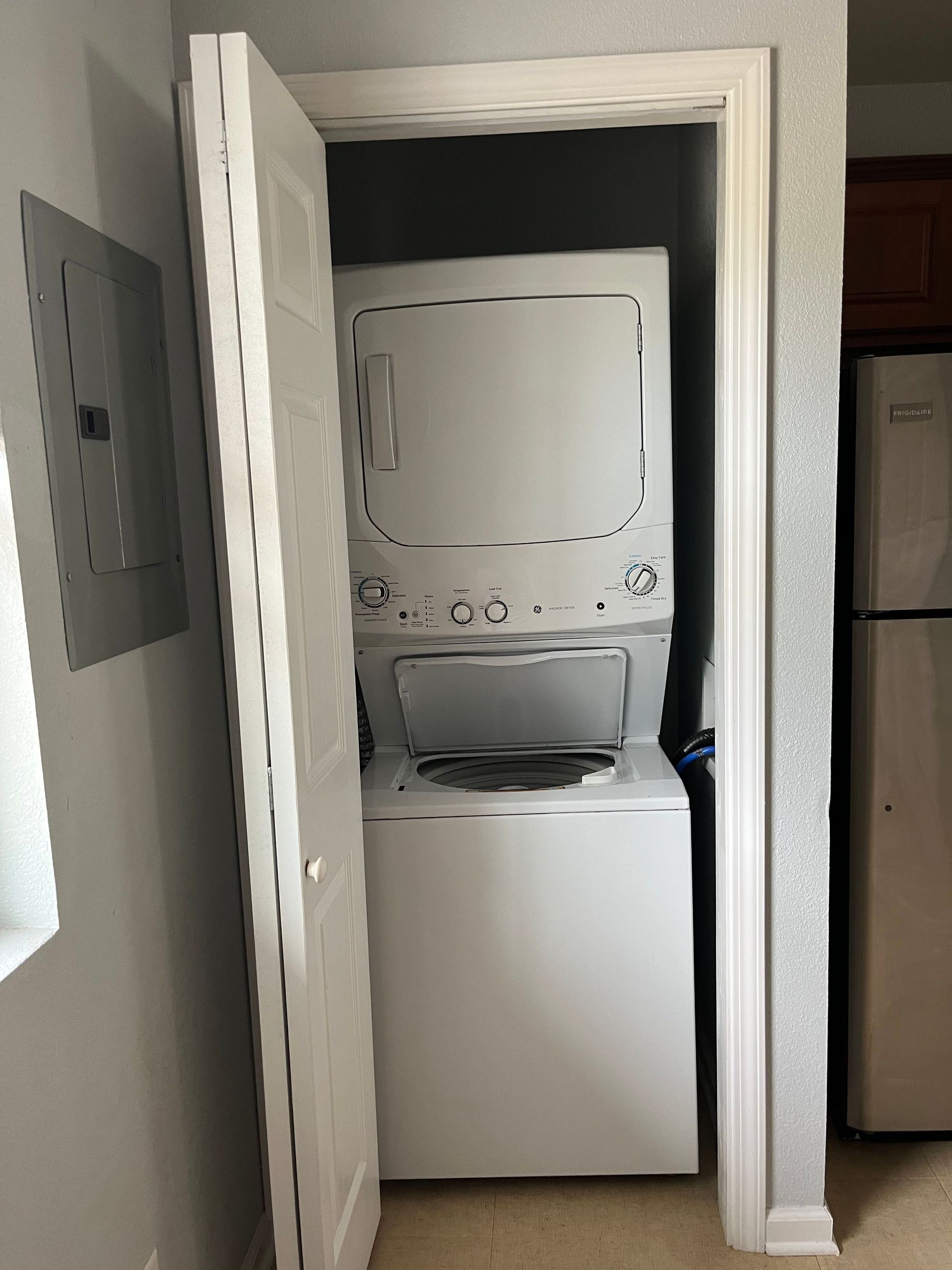 A washer and dryer are stacked on top of each other in a closet.