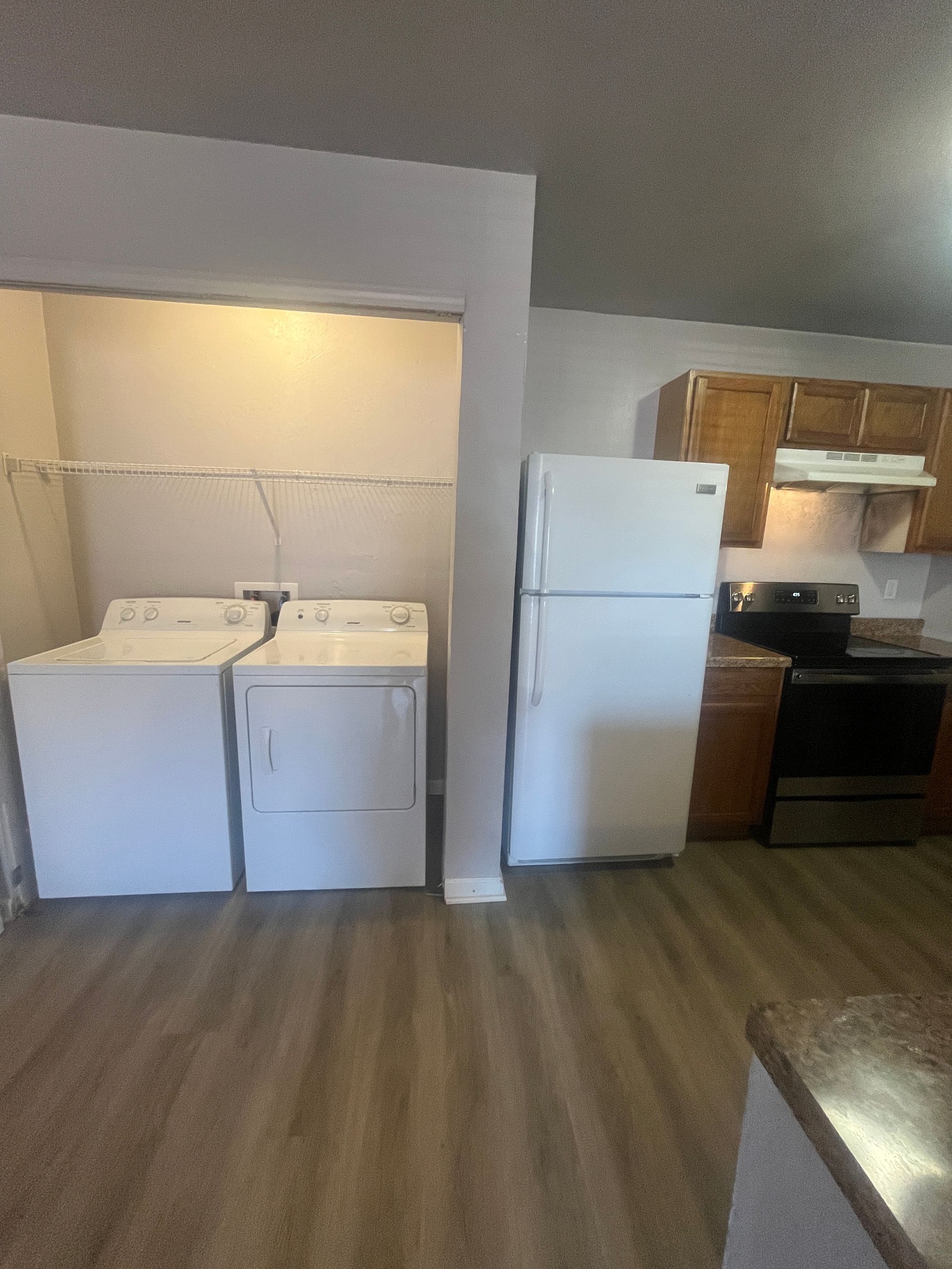 A kitchen with a washer and dryer and a refrigerator.