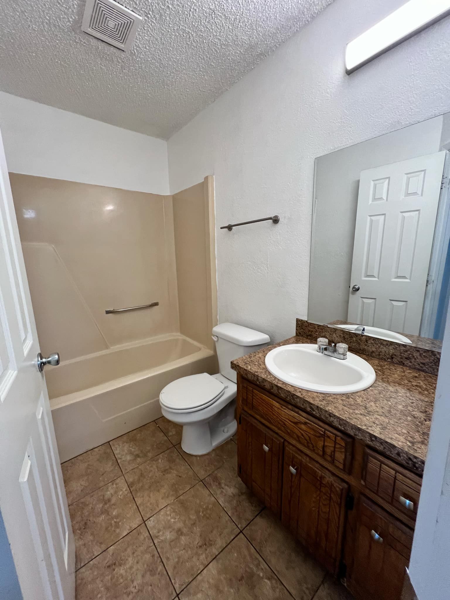 A bathroom with a toilet , sink and bathtub.