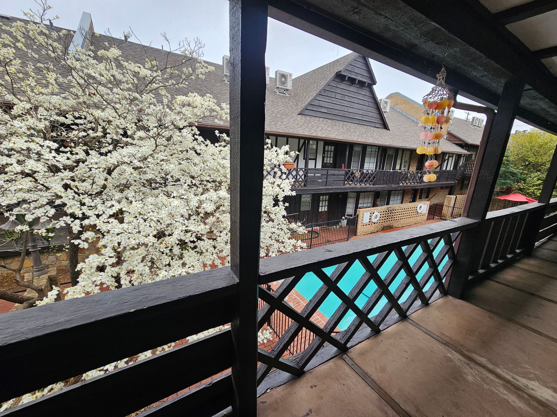 A balcony with a view of a building and a pool.