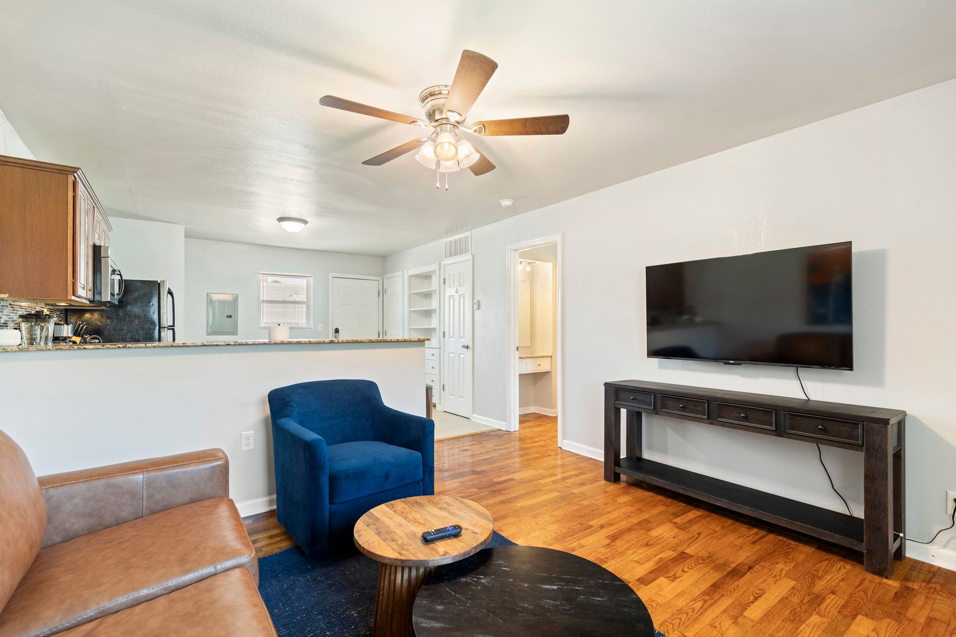A living room with a couch , chair , table and television.