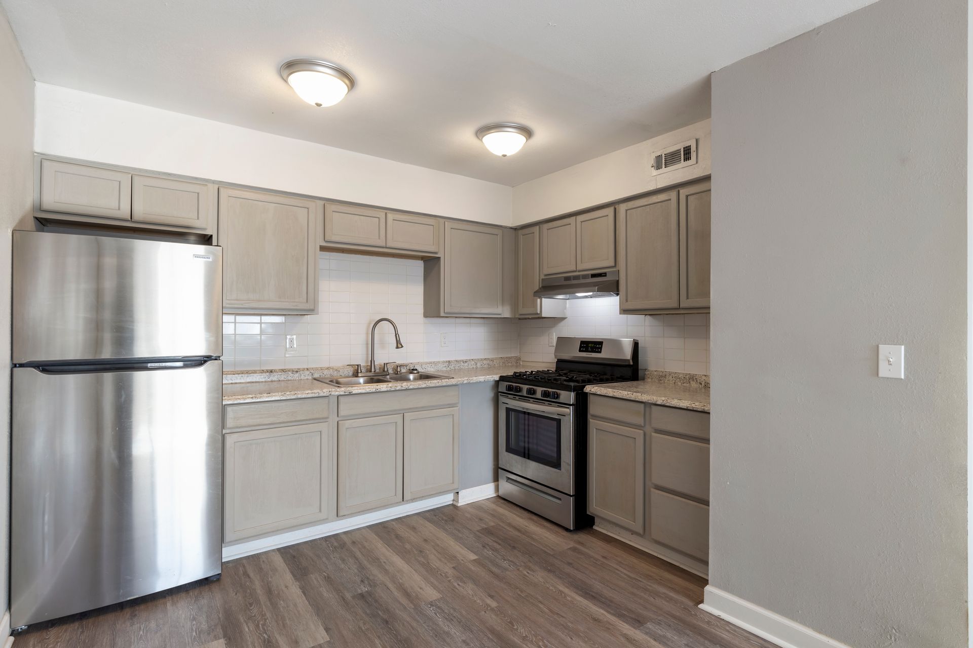 A kitchen with stainless steel appliances and gray cabinets