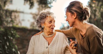 An elderly woman is talking to a younger woman.