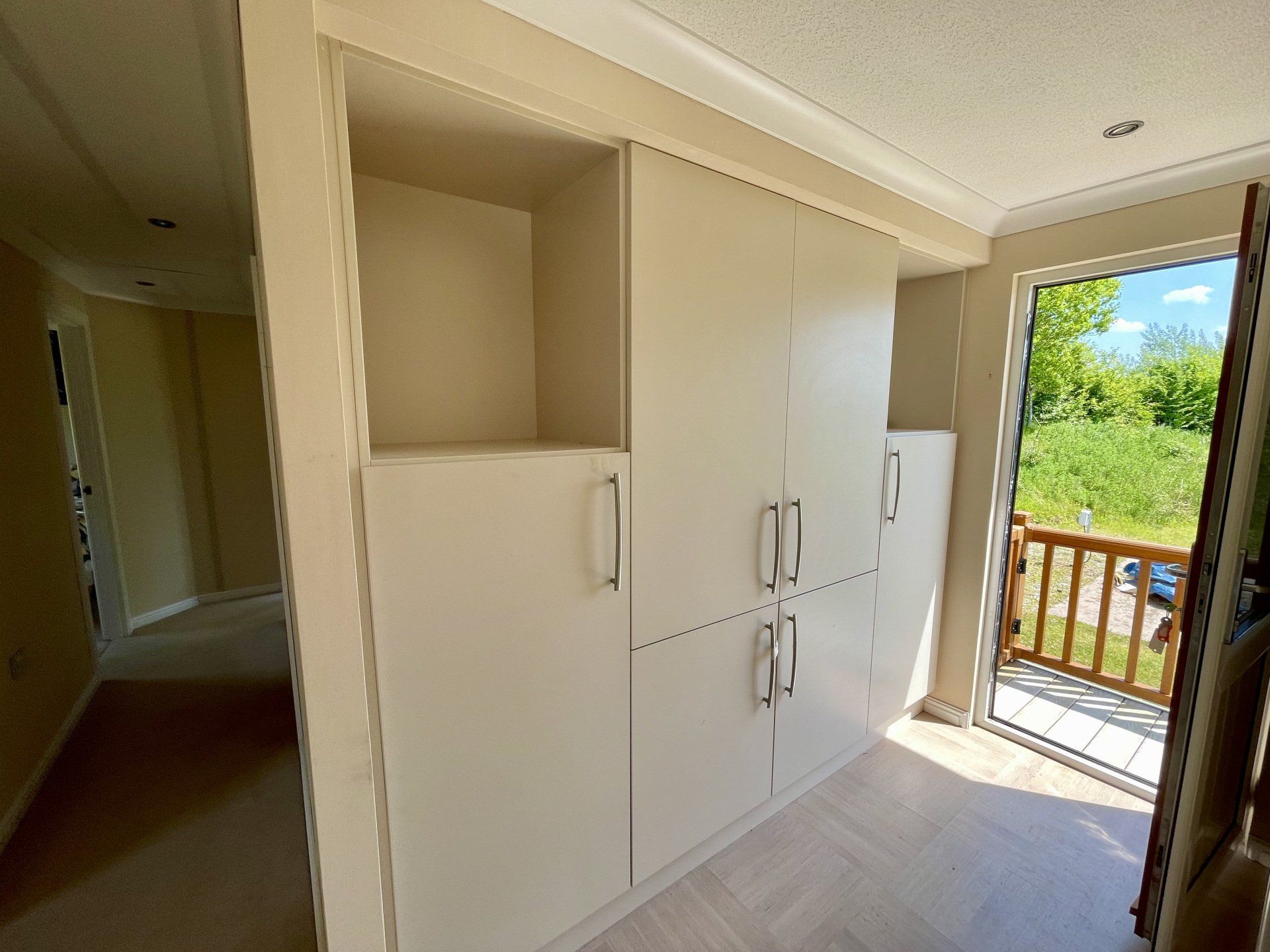 A room with white cabinets and a sliding glass door