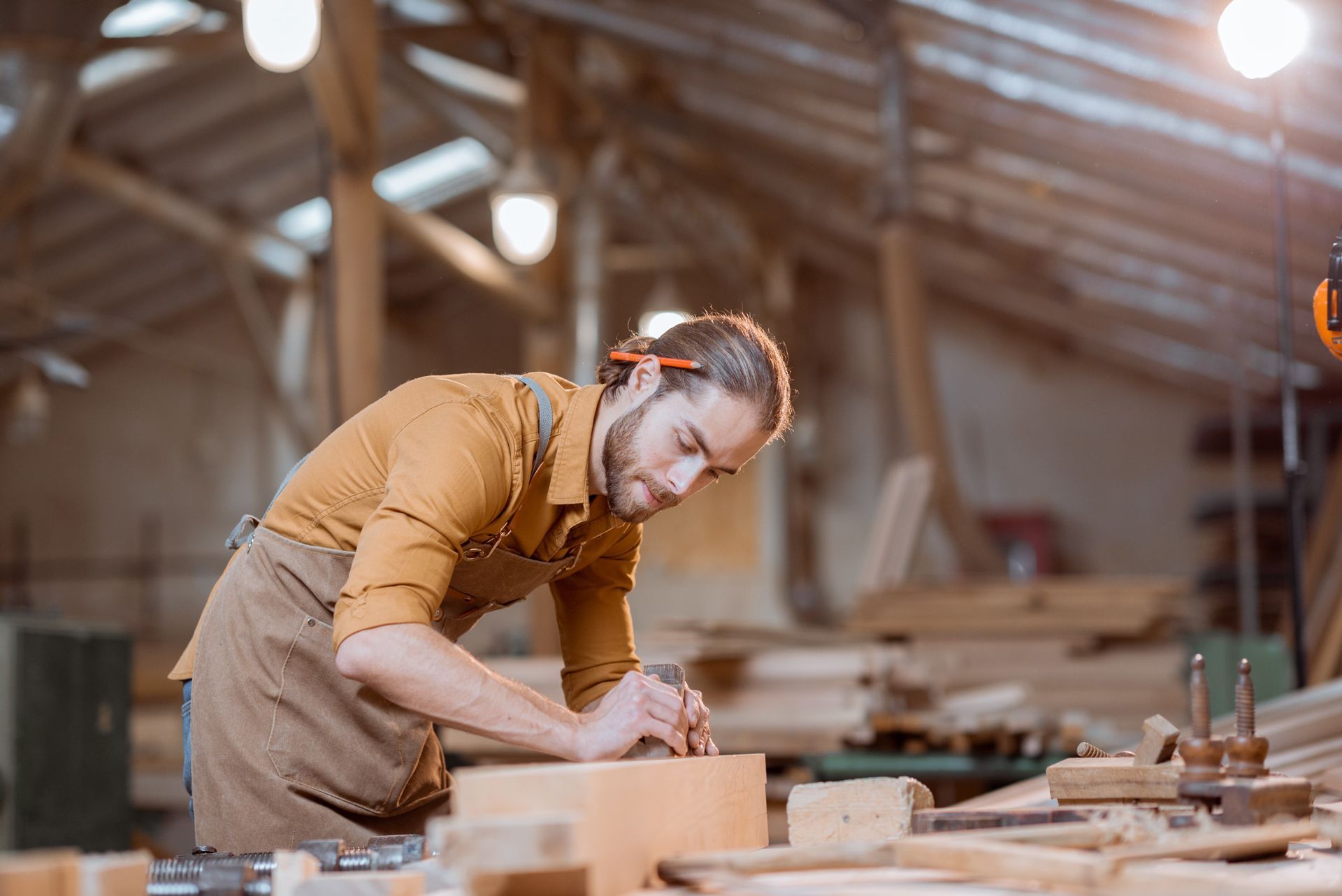 A man is working on a piece of wood in a workshop.