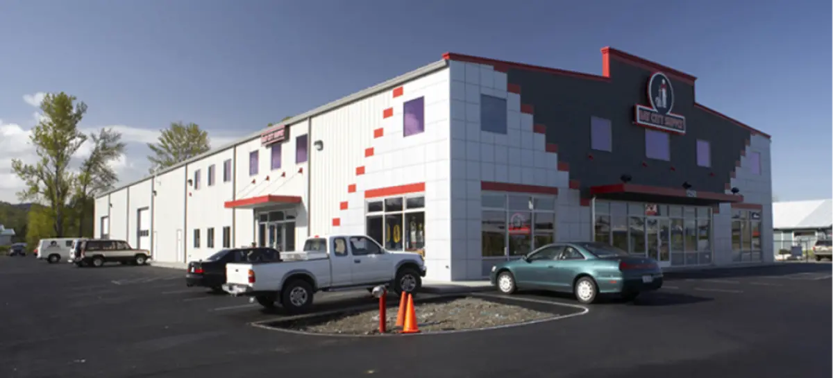 A large white building with cars parked in front of it