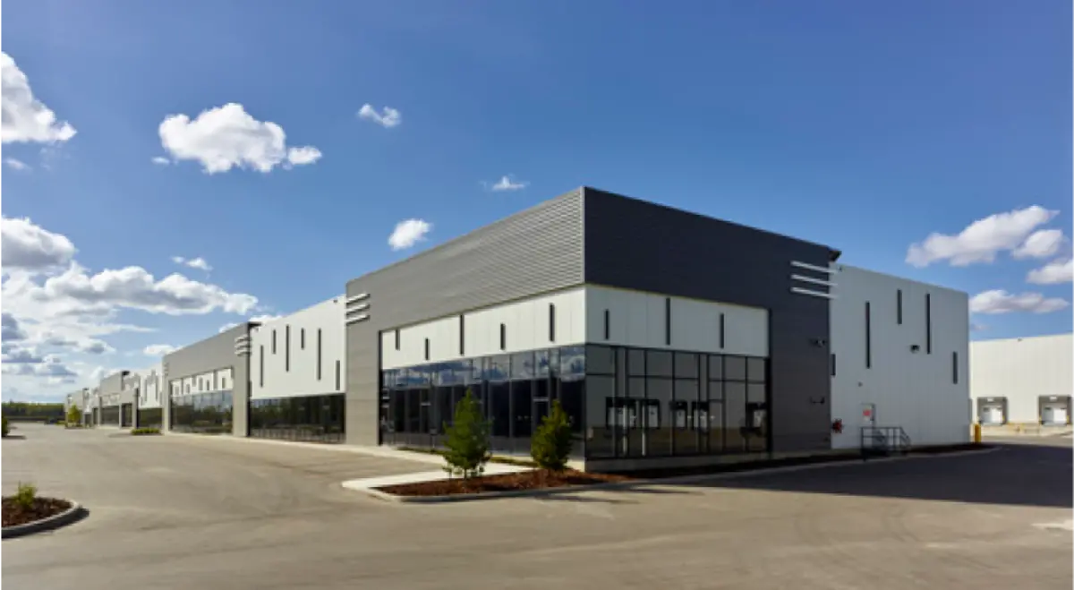 A large building with a lot of windows and a blue sky in the background.