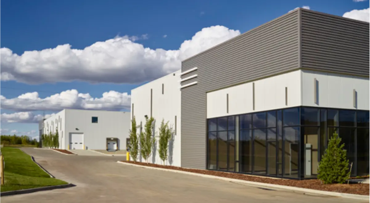A row of warehouses are lined up next to each other on a sunny day.