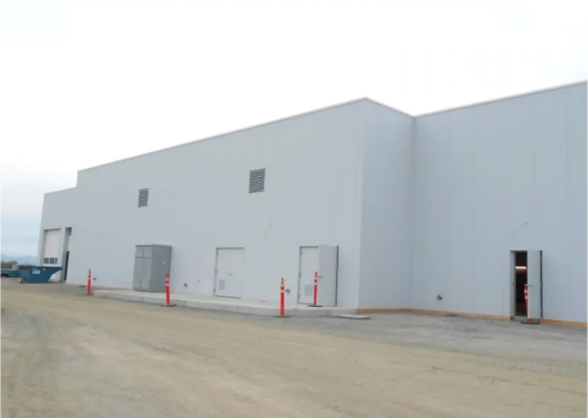 A large white building with red poles in front of it