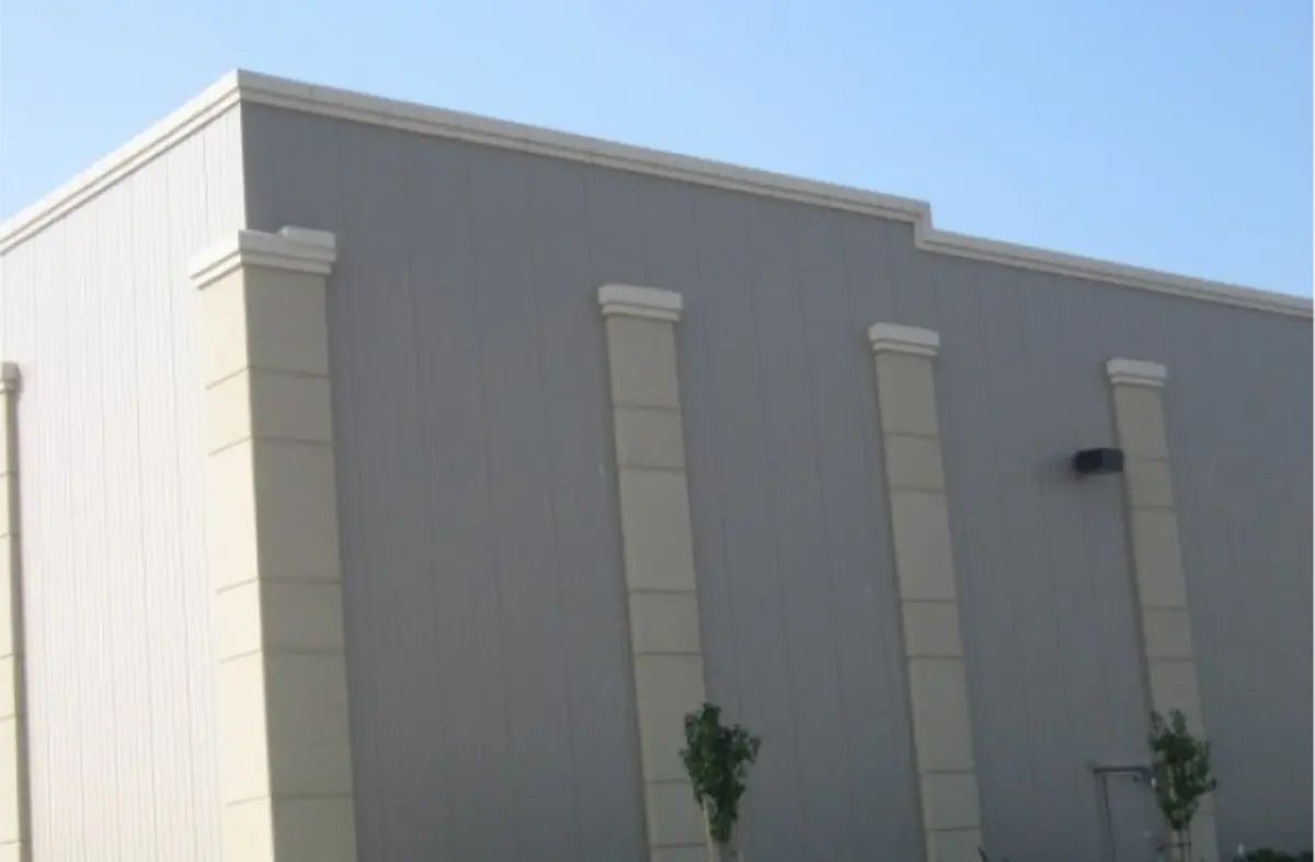 A large white building with a blue sky in the background