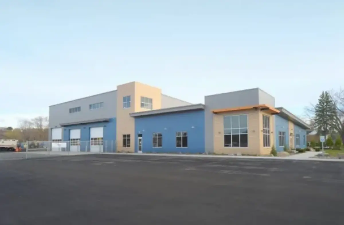 A large building with a lot of windows and a parking lot in front of it