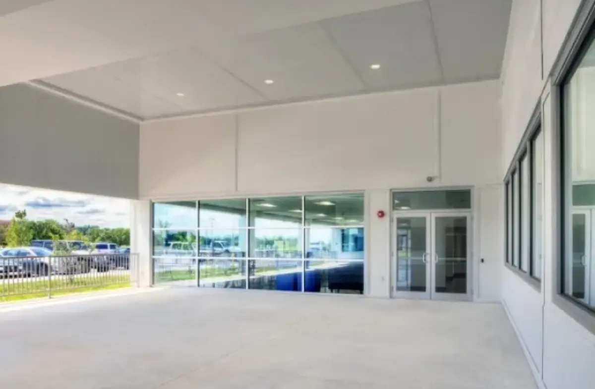 A large empty room with a lot of windows and a door.