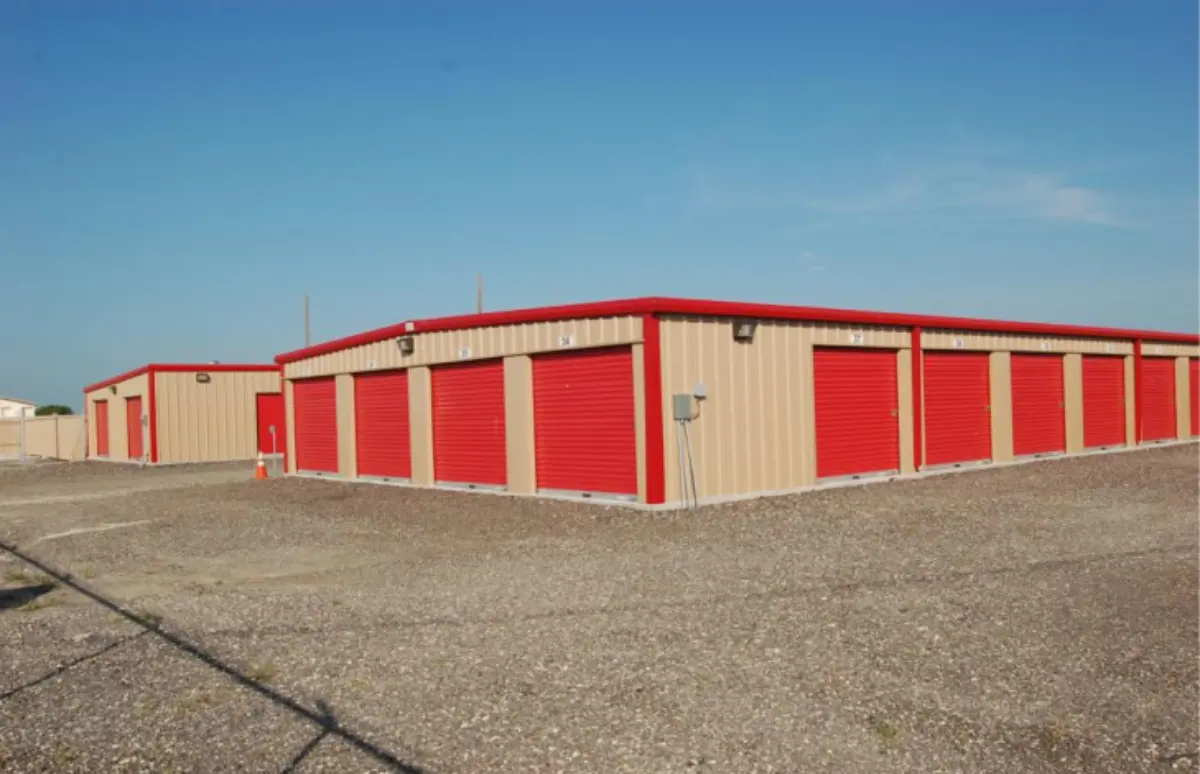 A row of storage units with red doors and a blue sky in the background
