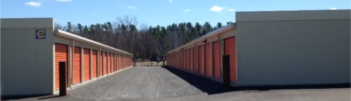 A row of storage units are lined up in a parking lot.